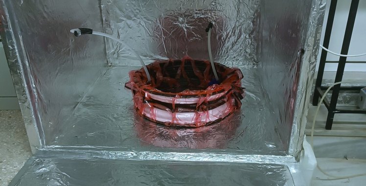 A carbon-fibre rim under red vacuum bagging inside the oven's foil-lined chamber